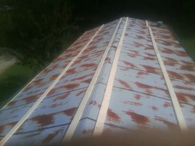 Rusted metal roof panels with new wood purlins before replacement — Storm Damage Roof Repair in Severna Park by Roofing Brothers
