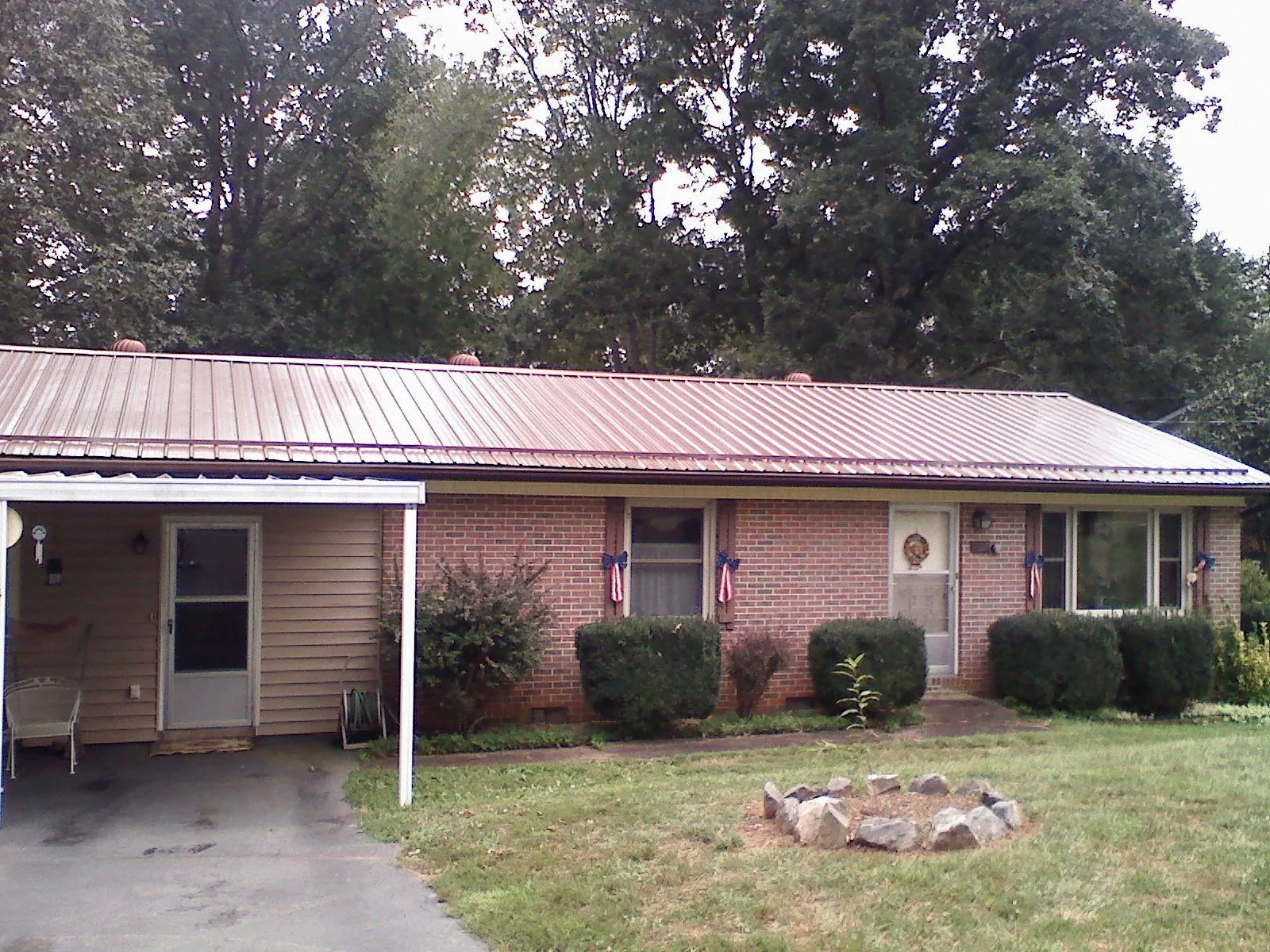 Bronze metal roof and carport on a brick ranch home — Roof Repair work by our crew in Severna Park