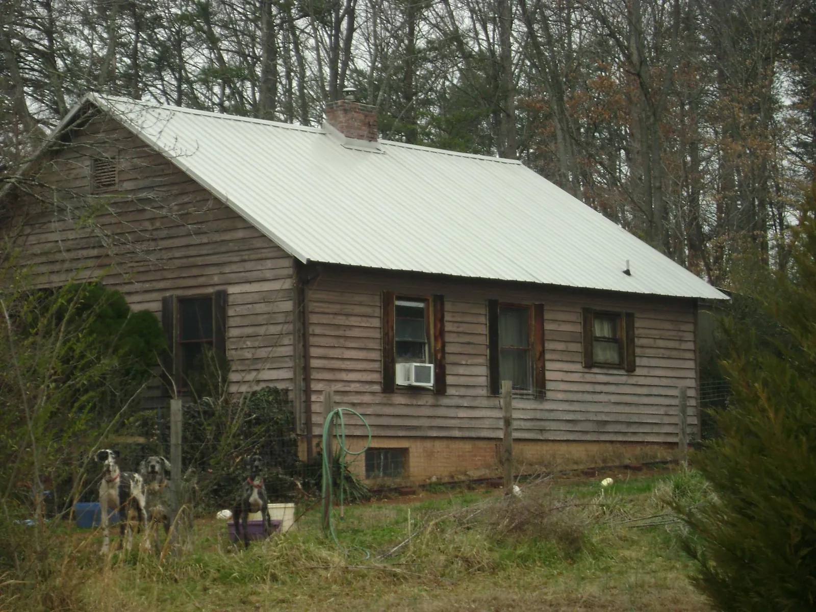 White metal roof on an old wood sided farmhouse, from a Metal Roof Installation job in Severna Park